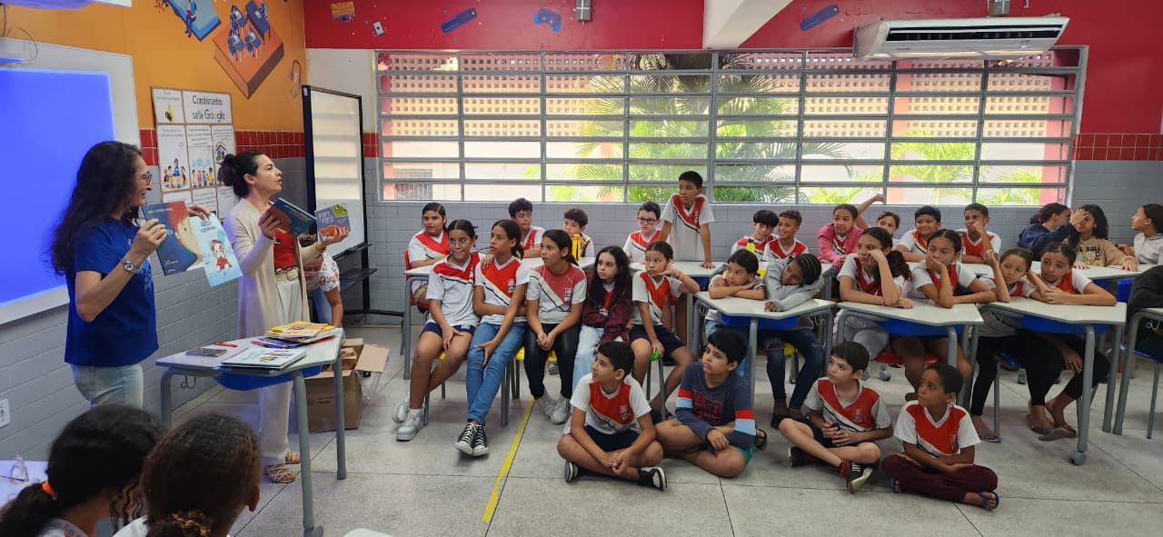 Crianças recebendo acervo literário