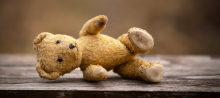 Foto de um urso de pelúcia caído no chão