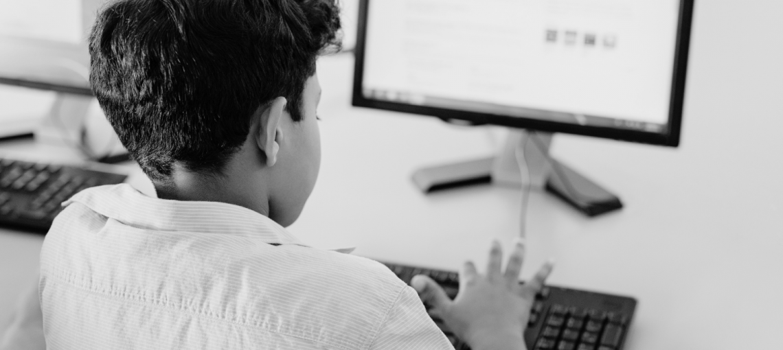 Foto em preto e branco de criança usando o computador
